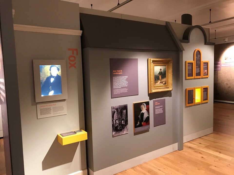 Several paintings and artwork at The Cooper Gallery, with a display nearby telling the story of them all.